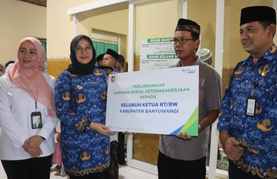 Bupati Banyuwangi, Ipuk Fiestiandani, menyerahkan BPJS Ketenagakerjaan pada Ketua RT/RW secara simbolis. (Dok: Humas Pemkab Banyuwangi)