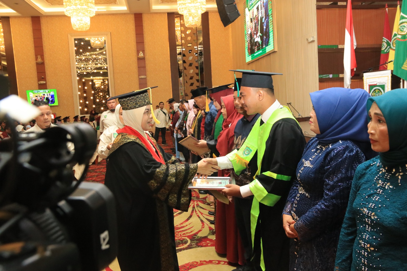 Rektor UISU Prof. Dr. Safrida, SE., M.Si menyerahkan penghargaan kepada salah alsatu wisudawan terbaik ketika wisuda Periode II UISU di di Selecta Convention Hall Medan, Sabtu, 23 Agustus 2025. (Istimewa)