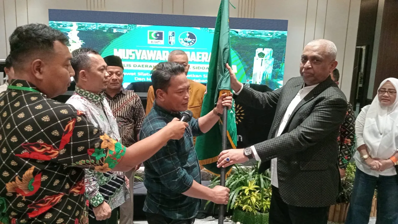 Sekretaris Umum (Sekum) Majelis Wilayah KAHMI Jatim, Akhsanul Yakin Rifat, saat serah terima pengibaran bendera petaka KAHMI ke Koordinator Presidium MD KAHMI Sidoarjo, Ahmad Riyadh Umar B. (Dok: Jurnas.net)