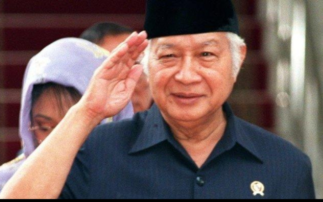File foto tertanggal 22 Mei 1998 ini menunjukkan mantan Presiden Indonesia Soeharto memberi hormat kepada para pengawal dan staf saat meninggalkan Istana Kepresiden. (AGUS LOLONG / AFP FILES / AFP)