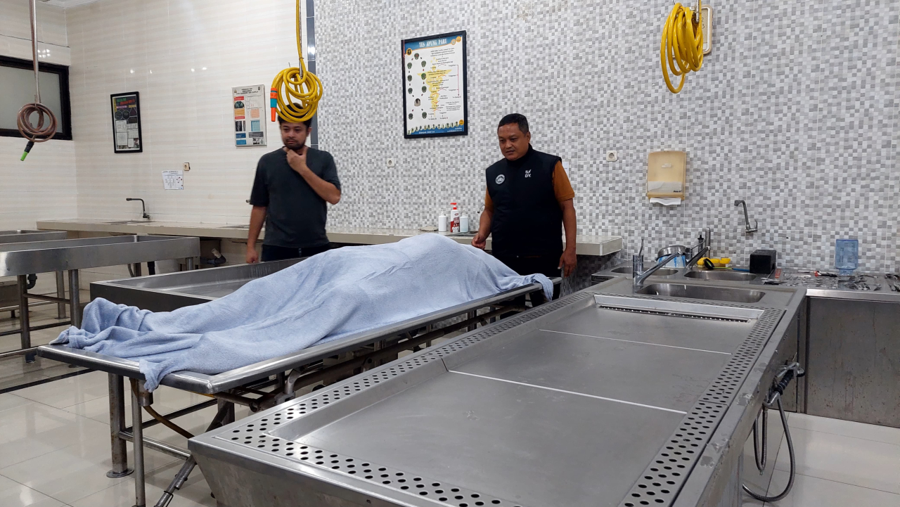 Kasubdit III Jatanras Ditreskrimum Polda Jatim AKBP Arbaridi Jumhur menunjukkan barang bukti di kamar jenazah RS Bhayangkara Surabaya. (Istimewa)