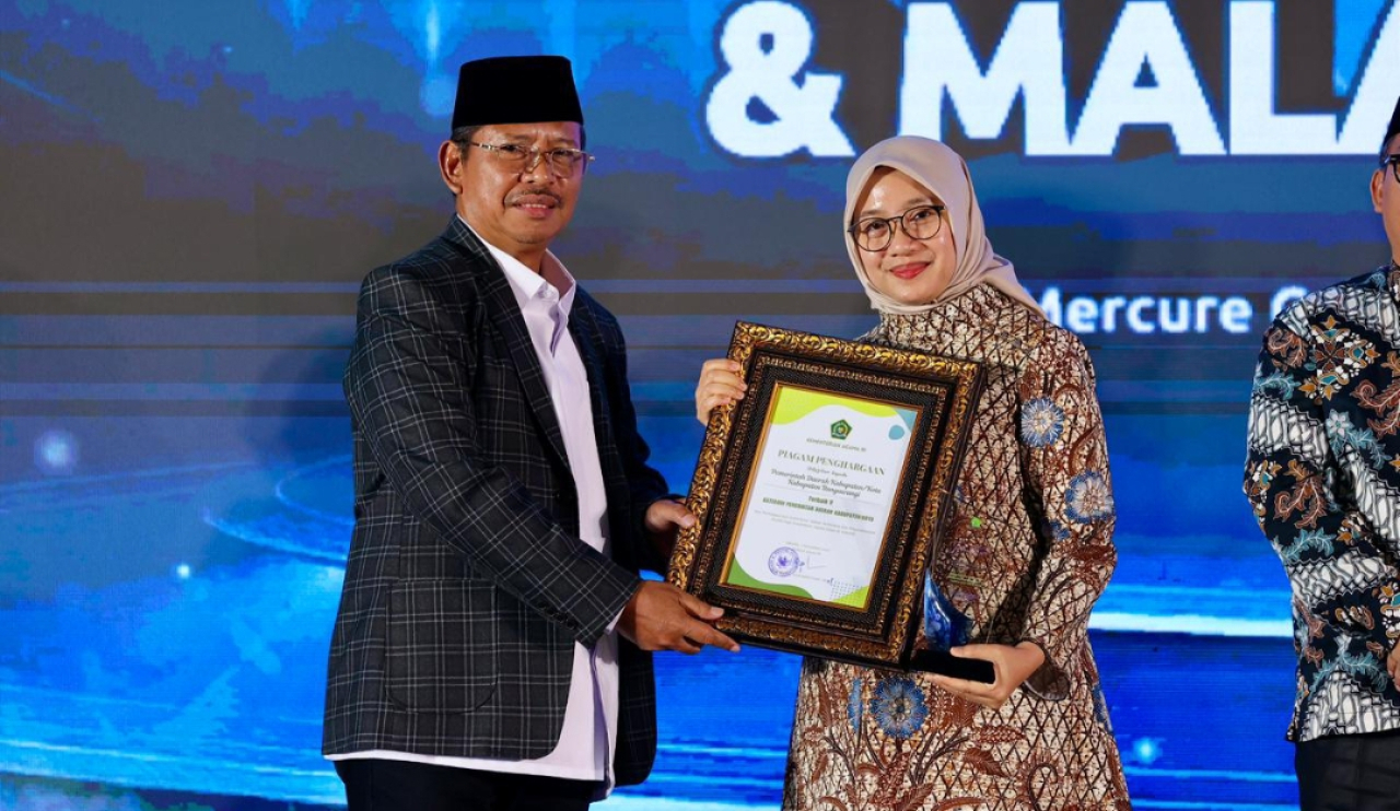 Sekjen Kemenag RI, Kamaruddin Amin, menyerahkan penghargaan kepada Bupati Banyuwangi Ipuk Fiestiandani. (Humas Pemkab Banyuwangi)