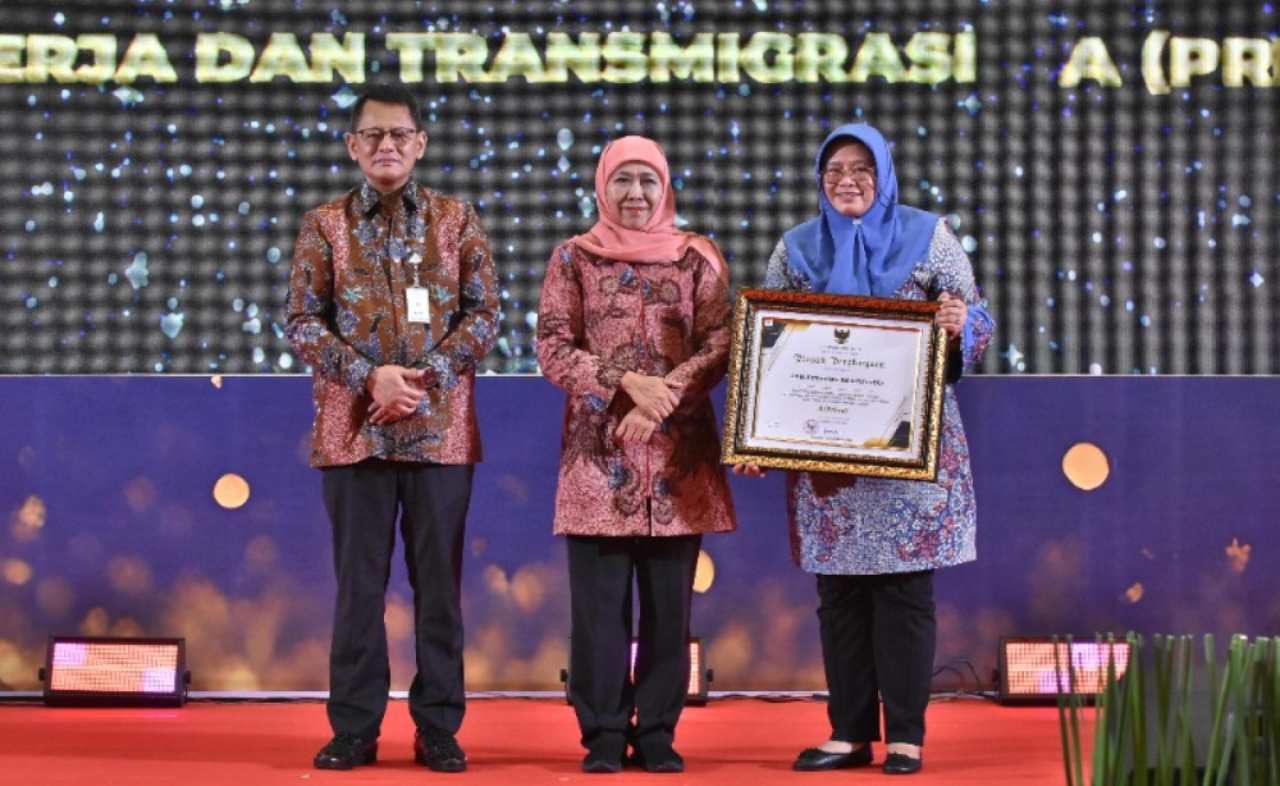 Gubernur Jawa Timur, Khofifah Indar Parawansa, menyerahkan penghargaan kepada Kepala Diskominfo Jatim, Sherlita Ratna Dewi Agustin. (Dok: Kominfo Jatim)