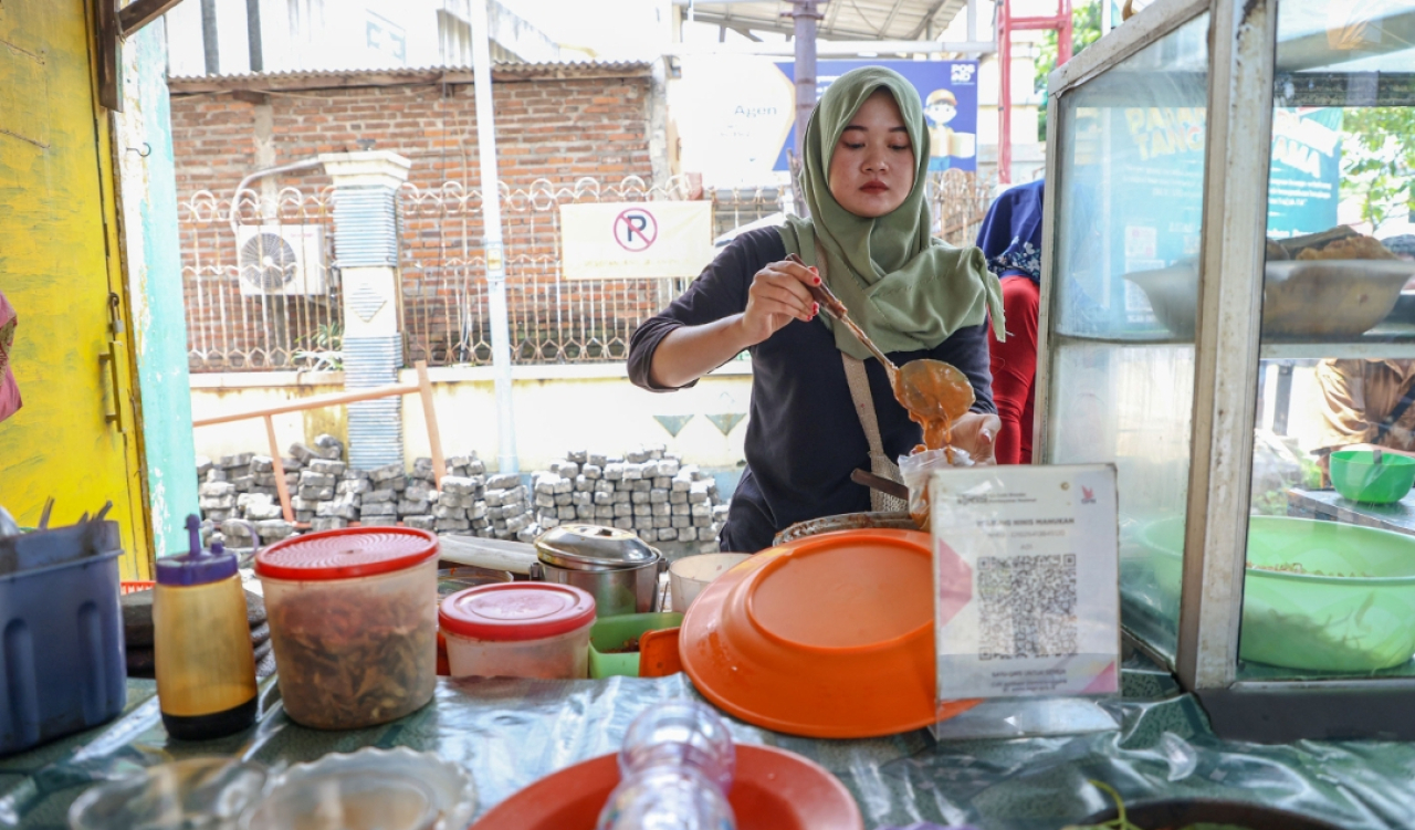 Anisah Wahyu Triska Setyoko Putri (21), penerima beasiswa tampak membantu ibunya menjual nasi penyetan di Surabaya. (Humas Pemkot Surabaya)