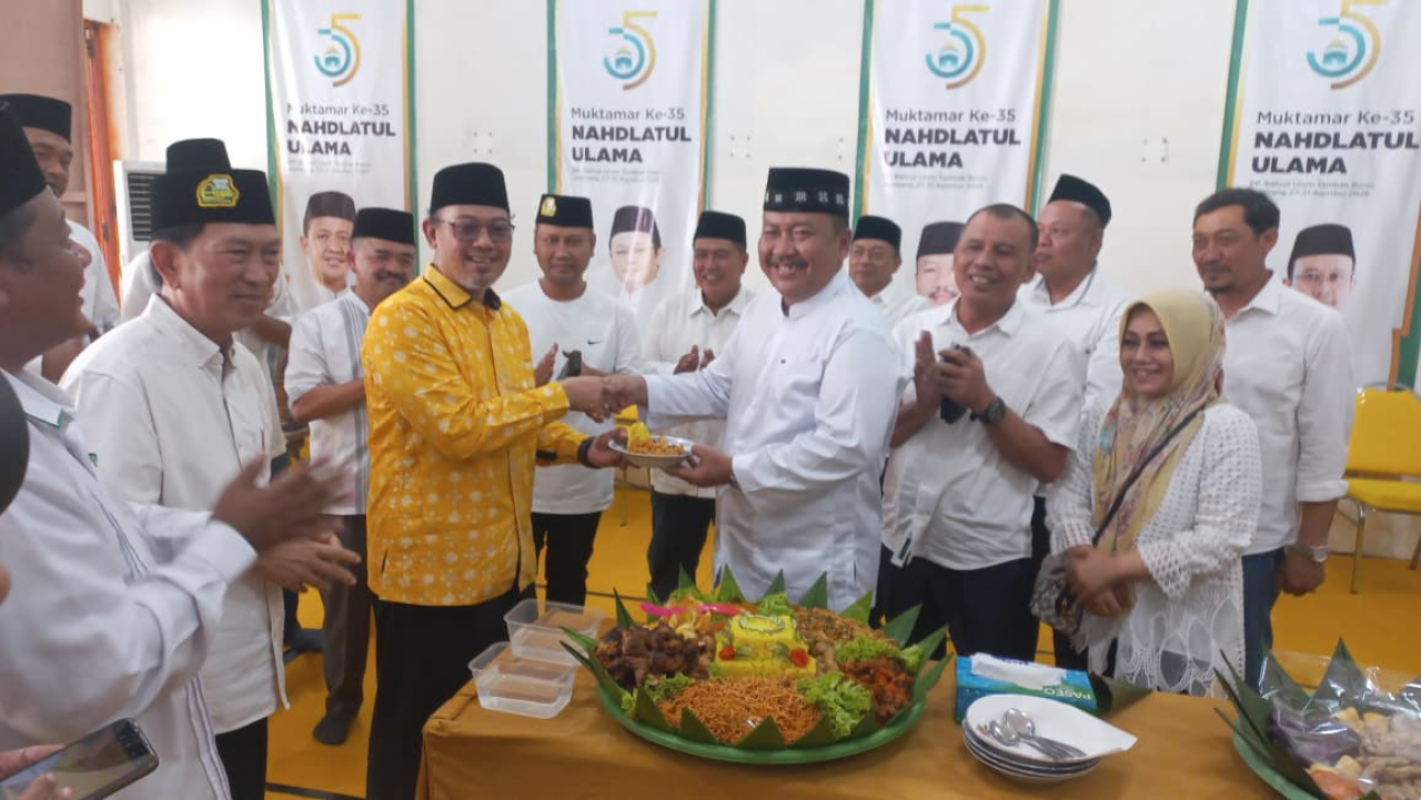 Ketua DPD Partai Golkar Jatim Ali Mufthi Ali menyerahkan potongan tumpeng kepada KH M. Solahul Amnotobuwono (Gus Am) dari Pondok Pesantren Bahrul Ulum, Jombang. (Insani/Jurnas.net)