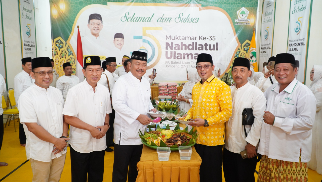 Ketua DPD Partai Golkar Jatim Ali Mufthi Ali menyerahkan potongan tumpeng kepada KH M. Solahul Amnotobuwono (Gus Am) dari Pondok Pesantren Bahrul Ulum, Jombang. (Insani/Jurnas.net)
