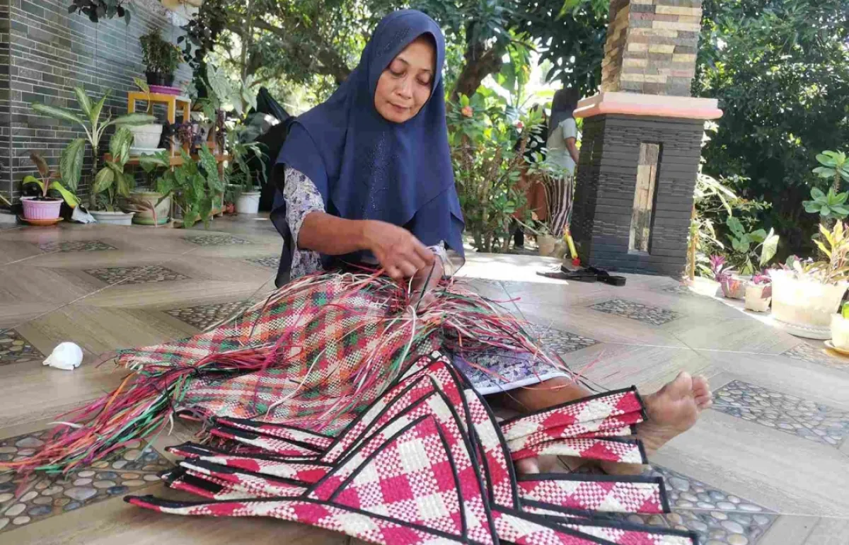 Seorang ibu tengah membuat anyaman tikar Bawean. (Istimewa)